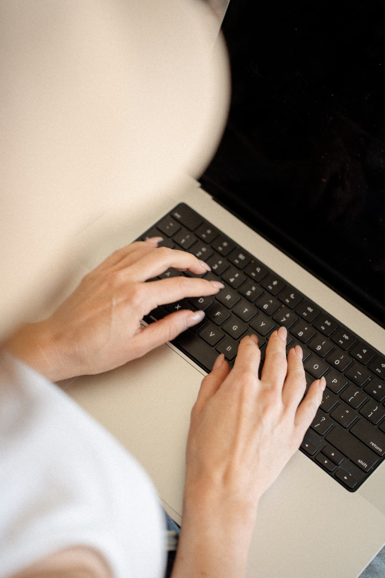 Hands at a laptop keyboard, close in